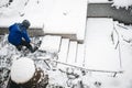 Man shovelling staircases with a snow shovel or pusher, topview