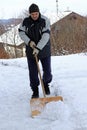 A man shovels snow from a sidewalk in the winter Royalty Free Stock Photo