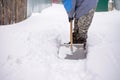 man shovels snow in the yard in winter. Clearing a road in a country village or village Royalty Free Stock Photo