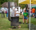 Man show cooking plum jam in traditional cauldron with sail mixer. Authentic process of preparation traditional method