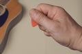 Man show how to correctly hold a guitar pick