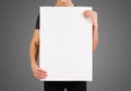 Man showing blank white big A2 paper. Leaflet presentation.