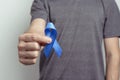 Man showing dark blue ribbon. Awareness ribbon