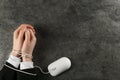 Man showing hands tied with computer mouse cable at grey table, top view and space for text. Internet addiction Royalty Free Stock Photo