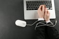 Man showing hands tied with computer mouse cable near laptop at black table, top view. Internet addiction Royalty Free Stock Photo