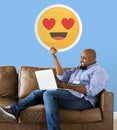 Man showing heart eyes emoticon on couch