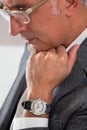 Man showing his watch while thinking with hand on chin Royalty Free Stock Photo