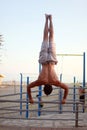 Man showing impressive strength, doing a handstand in beach Royalty Free Stock Photo