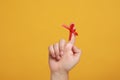 Man showing index finger with red tied bow as reminder on orange background, closeup Royalty Free Stock Photo