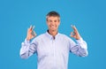 man showing OK sign with both hands over blue background