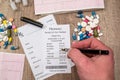 Man showing on pharmacy receipt with rx blank, pills, syringe