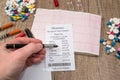 Man showing on pharmacy receipt with rx blank, pills, syringe