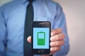 Man showing phone with green battery icon on screen. Royalty Free Stock Photo