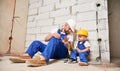 Man showing pliers tool to child in building under renovation. Royalty Free Stock Photo