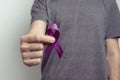 Man showing purple ribbon. Awareness ribbon