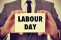 Man showing a signboard with the text labour day, filtered Royalty Free Stock Photo