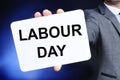 Man showing a signboard with the text labour day