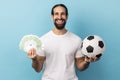 Man showing soccer ball and fun of hundred euro bills, winning lot of money betting for sport. Royalty Free Stock Photo