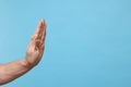 Man showing stop gesture on light blue background, closeup. Space for text Royalty Free Stock Photo