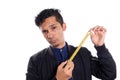 Man showing tape measure, white background. Young latino man showing how to use a tape measure. Royalty Free Stock Photo