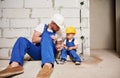 Man showing tool to child in apartment under renovation. Royalty Free Stock Photo