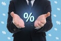 Man showing virtual percent sign on light blue background, closeup. Discount concept