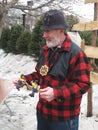 Man showing a wooden toy outside.