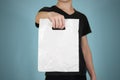 Man shows blank plastic bag mock up isolated. Empty white polyethylene package mockup. Consumer pack ready for logo design or ide Royalty Free Stock Photo