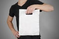 Man shows blank plastic bag mock up isolated. Empty white polyethylene package mockup. Consumer pack ready for logo design or ide Royalty Free Stock Photo
