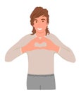 A man shows with his hands a gesture of heart, love. Young guy sincerely smiling, making a heart gesture near his chest