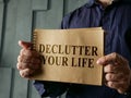 Man shows page with words declutter your life.