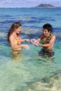 Man shows seashells to a young woman Royalty Free Stock Photo