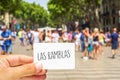 Man shows a signboard with the text Las Ramblas, at Las Ramblas Royalty Free Stock Photo