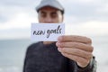 Man shows signboard with the text new goals