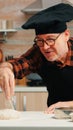 Man sieving flour over dough on table