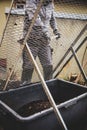 Man sifts compost soil into a tub