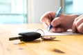 Man Signing Car Insurance Document Or Lease Paper.