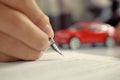 Man signing car insurance document. Writing signature on contract or agreement. Buying or selling new or used vehicle. Royalty Free Stock Photo