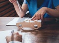 Man signing a car insurance policy, the agent is holding the wooden car model. Royalty Free Stock Photo