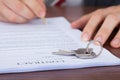 Man signing contract with keys on it Royalty Free Stock Photo