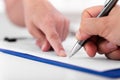 Man is signing a document on a blue clipboard Royalty Free Stock Photo