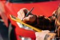 A man signs a document in front of a car close-up. the concept of machine insurance