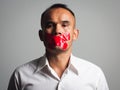 Man is silenced with adhesive red tape across his mouth sealed to prevent him from speaking. Freedom Concept Royalty Free Stock Photo