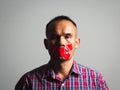 Man is silenced with adhesive red tape across his mouth sealed to prevent him from speaking. Freedom Concept Royalty Free Stock Photo