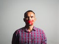 Man is silenced with adhesive red tape across his mouth sealed to prevent him from speaking. Freedom Concept Royalty Free Stock Photo