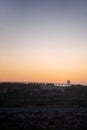 Man silhouette on a bycicle cycling on a pier in the beach at sunset, in Portugal Royalty Free Stock Photo