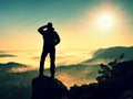 Man silhouette climbing high on cliff. Hiker climbed up to peak enjoy view.