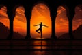 Man silhouette doing yoga in old temple with orange sunset sky background Royalty Free Stock Photo