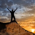 Man silhouette with hands rising up stay on a mount top at the sunset Royalty Free Stock Photo