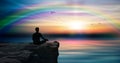 Yoga man silhouette meditating at sunset colorful rainbow sky nature landscape Royalty Free Stock Photo